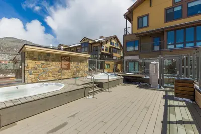 a building with a hot tub on a deck at Slopeside Unit 2755 in Keystone