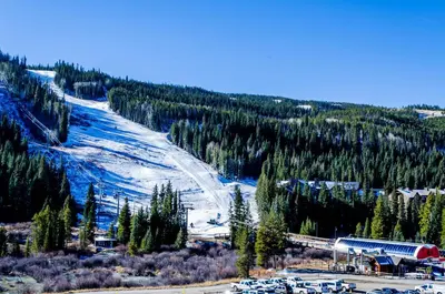 a snow covered mountain with a ski resort and a train at Slopeside Unit 2755 in Keystone