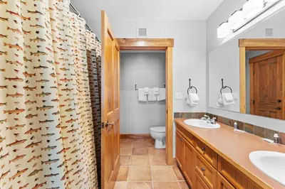 a bathroom with two sinks and a shower curtain at Springs Unit 8865 in Keystone