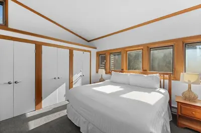 a bedroom with a white bed and some windows at Tennis Townhome Unit 1321 in Keystone