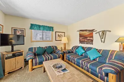 a living room with couches and a flat screen tv at Snowdance 204A in Keystone
