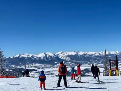 a group of people skiing on a ski slope at Snowdance 204A in Keystone