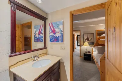 a bathroom with a sink and a mirror and a bedroom at The Lodge at Lake Dillon 308 in Dillon