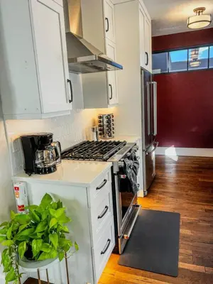 a kitchen with white cabinets and a stove top oven at 9 Min Walk to Pearl Street - Downtown Boulder in Boulder