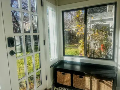 a room with two windows and a bench next to a door at 9 Min Walk to Pearl Street - Downtown Boulder in Boulder