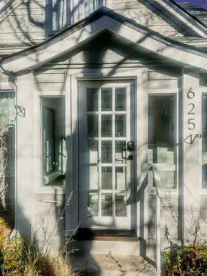 a white house with a door and a window at 9 Min Walk to Pearl Street - Downtown Boulder in Boulder
