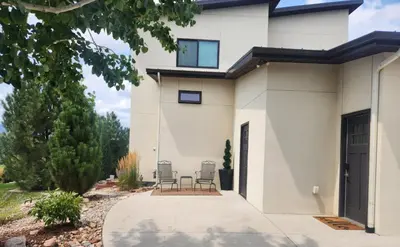 a white house with two chairs on a driveway at Scenic Golf Course Retreat near CSU & Estes Park! in Loveland