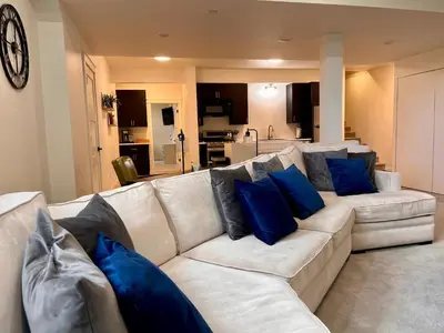 a living room with a white couch with blue pillows at Scenic Golf Course Retreat near CSU & Estes Park! in Loveland