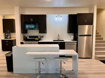 a kitchen with a white counter and a refrigerator at Scenic Golf Course Retreat near CSU & Estes Park! in Loveland