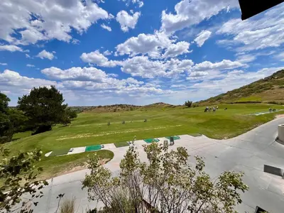 a view of a golf course with mountains in the background at Scenic Golf Course Retreat near CSU & Estes Park! in Loveland