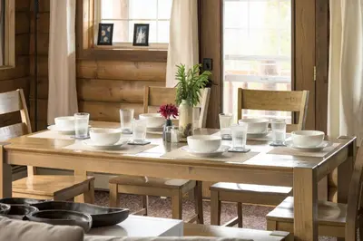 a wooden table with bowls and plates on it at The Moose Hoose Cabin With Views and Game Room in Black Hawk