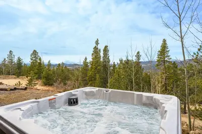 a hot tub in the middle of a forest at The Moose Hoose Cabin With Views and Game Room in Black Hawk