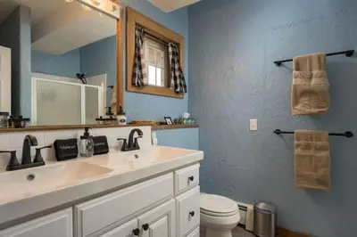 a bathroom with a sink and a mirror and a toilet at The Moose Hoose Cabin With Views and Game Room in Black Hawk