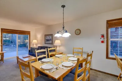a dining room and living room with a table and chairs at Woodsy Winter Park Condo with Pool and Hot Tub Access in Winter Park