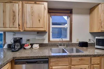 a kitchen counter with a sink and a window at Woodsy Winter Park Condo with Pool and Hot Tub Access in Winter Park