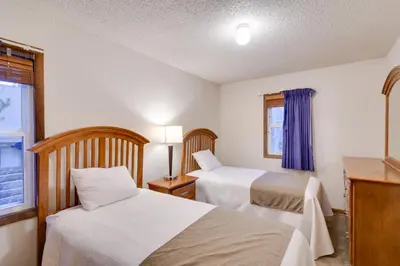 a hotel room with two beds and a window at Woodsy Winter Park Condo with Pool and Hot Tub Access in Winter Park