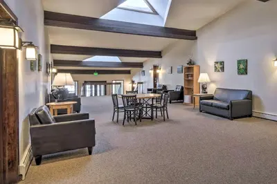 a living room with couches and a table and chairs at Woodsy Winter Park Condo with Pool and Hot Tub Access in Winter Park