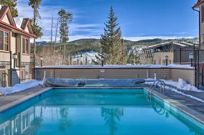 a swimming pool in front of a house at Woodsy Winter Park Condo with Pool and Hot Tub Access in Winter Park