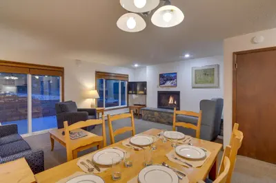 a dining room with a table and chairs and a fireplace at Shuttle to Winter Park Resort! Group Condo with Pool in Winter Park