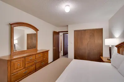 a bedroom with a bed and a dresser and a mirror at Shuttle to Winter Park Resort! Group Condo with Pool in Winter Park