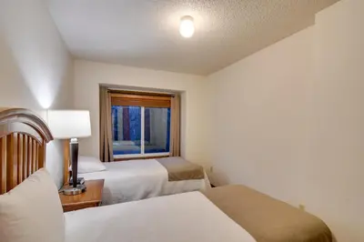 a bedroom with two beds and a window at Shuttle to Winter Park Resort! Group Condo with Pool in Winter Park