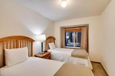 a hotel room with two beds and a window at Shuttle to Winter Park Resort! Group Condo with Pool in Winter Park