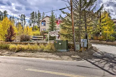 a house on the side of a road with a flag at Ski, Soak and Chill! Pool-View Winter Park Condo in Winter Park