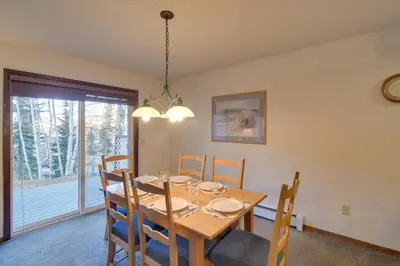 a dining room with a wooden table and chairs at 3 Mi to Skiing Walkable Dtwn Winter Park Condo! in Winter Park