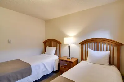 a hotel room with two beds and a lamp at 3 Mi to Skiing Walkable Dtwn Winter Park Condo! in Winter Park