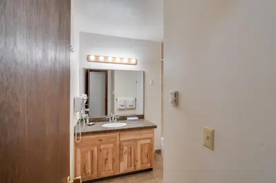a bathroom with a sink and a mirror at 3 Mi to Skiing Walkable Dtwn Winter Park Condo! in Winter Park