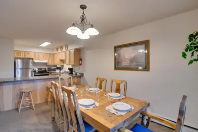 a kitchen and dining room with a wooden table and chairs at Hot Tub and Heated Pool! Ski Retreat in Winter Park in Winter Park