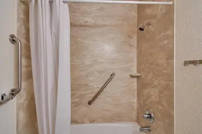 a shower with a white shower curtain in a bathroom at Ski and Hike! Easy Adventuring at Winter Park Condo in Winter Park