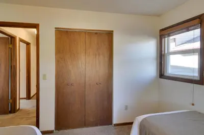 a bedroom with a wooden closet and a window at Ski and Hike! Easy Adventuring at Winter Park Condo in Winter Park