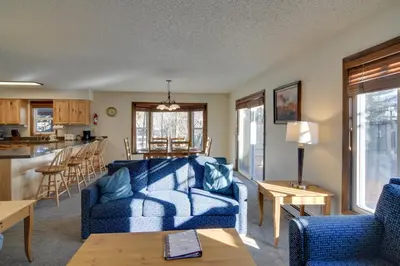a living room with blue couches and a kitchen at Ski and Hike! Easy Adventuring at Winter Park Condo in Winter Park
