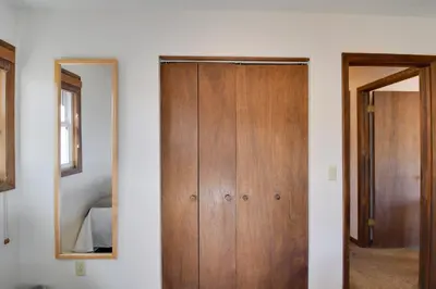 a wooden door in a room with a mirror at Walk to Ski Shuttle! Ideal Winter Park Base Camp in Winter Park