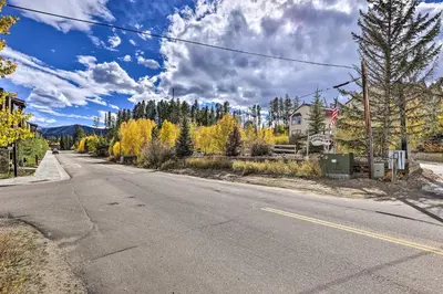 an empty road with trees and a house in the distance at Walk to Ski Shuttle! Ideal Winter Park Base Camp in Winter Park