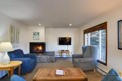 a living room with two chairs and a fireplace at Walk to Ski Shuttle! Ideal Winter Park Base Camp in Winter Park