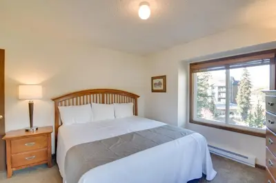 a bedroom with a white bed and a window at Walk to Ski Shuttle! Ideal Winter Park Base Camp in Winter Park