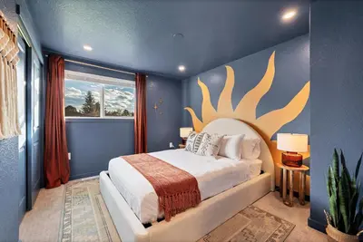 a bedroom with a bed with a large antler painting on the wall at Outdoor Movie - Pingpong & Volleyball - Cozy 5BD in Denver