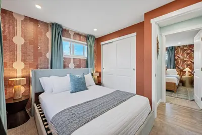 a bedroom with a large bed with orange walls at Outdoor Movie - Pingpong & Volleyball - Cozy 5BD in Denver