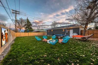 a yard with chairs and a table in the grass at Outdoor Movie - Pingpong & Volleyball - Cozy 5BD in Denver