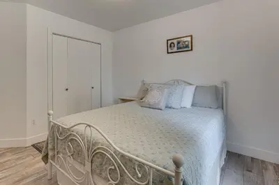 a white bedroom with a bed with blue pillows at 4 Mi to TPC Colorado Dog-Friendly Gem in Berthoud in Berthoud