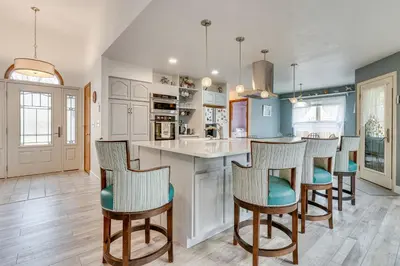 a kitchen with a island with bar stools at 4 Mi to TPC Colorado Dog-Friendly Gem in Berthoud in Berthoud
