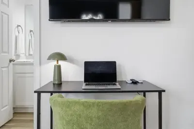a laptop on a desk with a green chair at Sleeps 8, Fire pit, Near DIA & Downtown Denver in Commerce City
