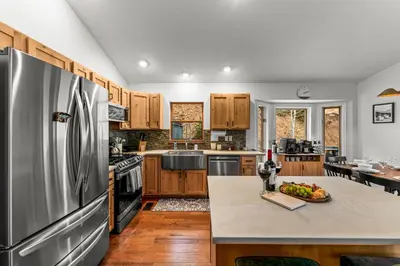 a kitchen with a stainless steel refrigerator and wooden cabinets at Luxury Mountain Views, hot tub, peaceful retreat in Black Hawk