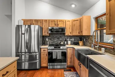 a kitchen with wooden cabinets and a stainless steel refrigerator at Luxury Mountain Views, hot tub, peaceful retreat in Black Hawk
