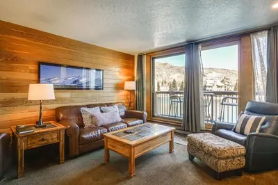 a living room with a couch and a table at Continental Divide Views Lakefront Keystone Condo in Keystone