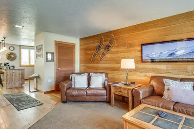 a living room with a couch and a tv at Continental Divide Views Lakefront Keystone Condo in Keystone