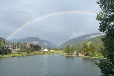 a rainbow over a lake with houses and a town at Continental Divide Views Lakefront Keystone Condo in Keystone