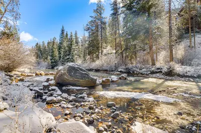 a stream with a rock in the middle of a forest at Continental Divide Views Lakefront Keystone Condo in Keystone